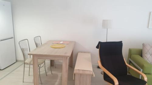 普里什蒂纳White Apartments的一间带木桌和椅子的用餐室