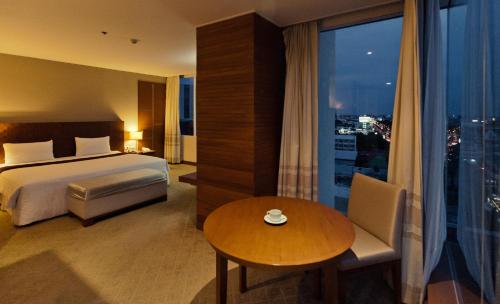 乌汶苏内大酒店和会议中心的酒店客房设有床、桌子和窗户。