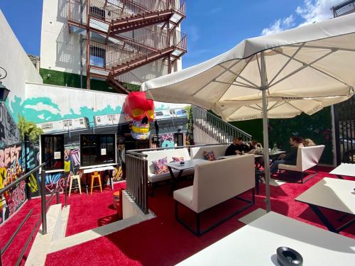 埃尔阿雷纳尔We Street Hostel - El Arenal-Albergue juvenil的一个带桌椅和遮阳伞的庭院