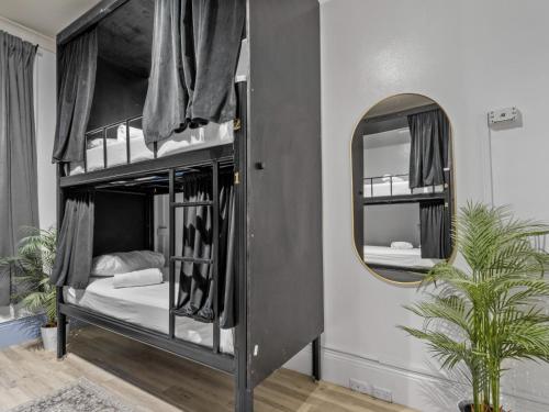悉尼Sydney Pod Hotels - Darling Harbour的一间卧室配有两张双层床和镜子