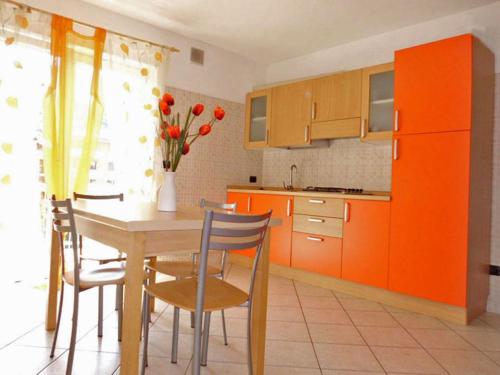 托尔博莱Agritur Laura的厨房配有橙色橱柜和桌椅