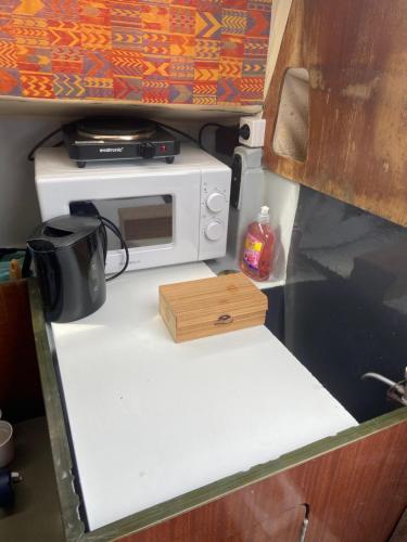 拉罗谢尔Nuit insolite dans un petit voilier的微波炉烤箱,放在一个rv的柜台上