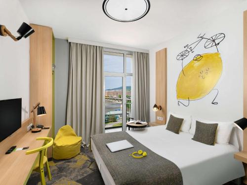 布达佩斯布达佩斯市宜必思尚品酒店的酒店客房设有一张大床和一张书桌。