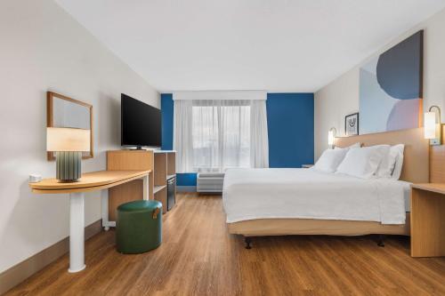 温彻斯特温彻斯特温德姆集团温盖特酒店的酒店客房设有一张大床和一张书桌。
