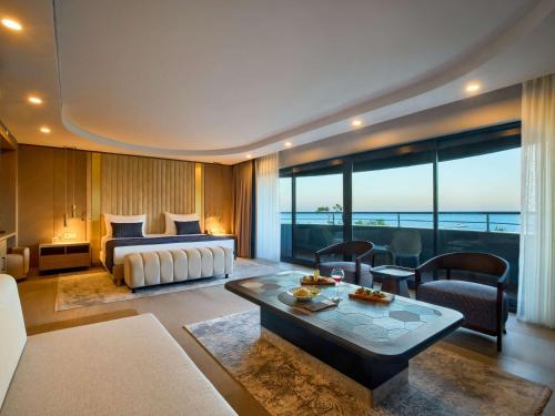 特基罗瓦Movenpick Resort Antalya Tekirova的酒店客房设有床和客厅。