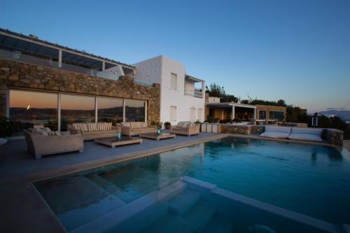 奥诺斯Amaris Mykonian Residence的一个带长沙发的游泳池和一个房子