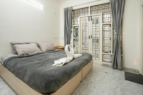 班加罗尔Aishwarya Mystic Apartotel的一间卧室,床上有一只白色动物