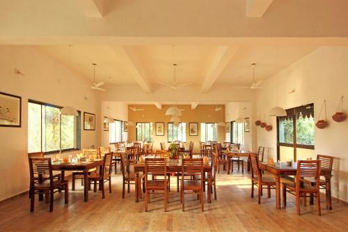 萨三吉尔Gir Birding Lodge的用餐室配有木桌和椅子