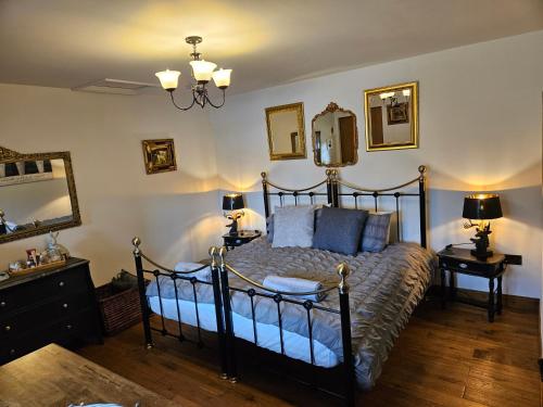 金顿Lyonshall Lodge的一间卧室配有一张床、两盏灯和一面镜子
