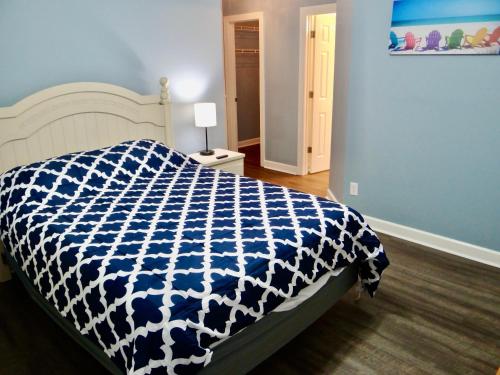 默特尔比奇The Inlet Outlet-Free Park Pass Included的一间卧室配有一张带蓝色和白色棉被的床