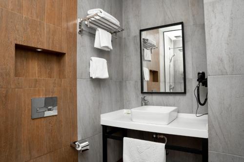 巴库Port Rivoli Baku Luxury Boutique Hotel的一间带水槽和镜子的浴室