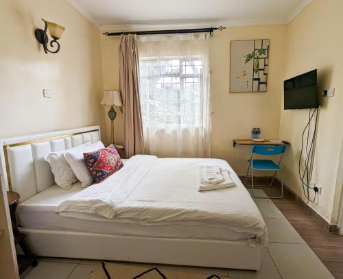 内罗毕DB Space的一间卧室配有一张床、一张书桌和一个窗户。