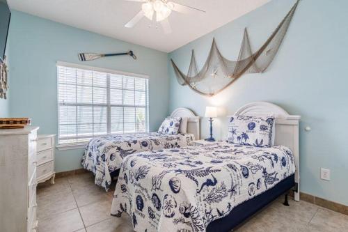 奥兰治比奇Orange Beach Villas - Casa Bella的卧室设有两张床铺和蓝色的墙壁