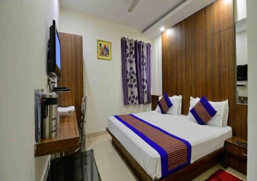 新德里Hotel University Stay @ A1Rooms的酒店客房,配有床和电视