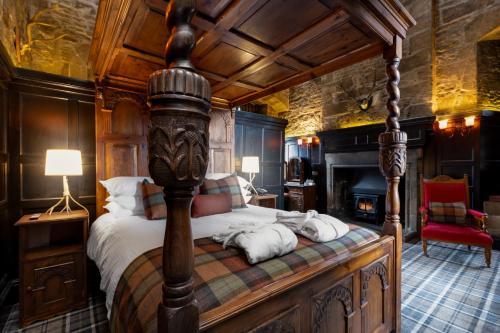 多诺赫多尔诺奇城堡酒店的一间卧室设有一张华盖床和壁炉