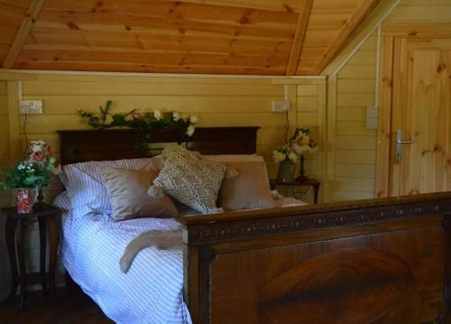 基尔肯尼Apple blossom glamping的一间卧室配有一张带枕头的木床