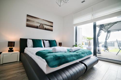扎托尔Dom z basenem & jacuzzi do 10 osób Zator Willa LuxHouse的一间卧室配有一张带绿色和白色床单的大床