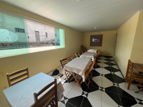 皮拉尼亚斯Pousada Girassol的客房设有2张桌子和椅子以及窗户。
