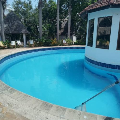 达累斯萨拉姆Haven Resort的度假村内的一个蓝色海水游泳池