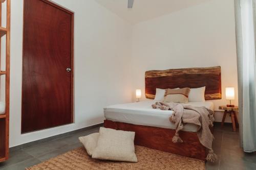 兹波利特Che Zipolite Hostel & Naked Beach Club的一间卧室配有一张带木制床头板的床