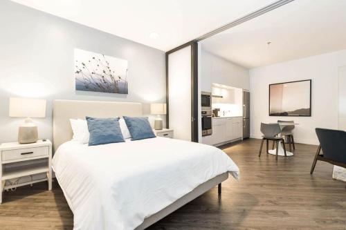 土桑Landing at RendezVous Urban Flats - 2 Bedrooms in South Tucson的卧室配有一张白色大床和一张书桌