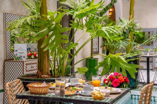 马拉喀什Riad Samir Privilege Boutique Hotel & Spa的桌上放着食物和饮料,上面放着植物