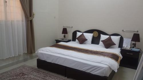 Al Nairyahالعييري للشقق المفروشة االنعيريه 1的一间卧室配有一张大床,配有两盏灯和地毯