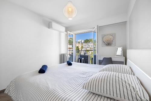 尼斯Le Hammam的一间白色卧室,配有两张床和窗户