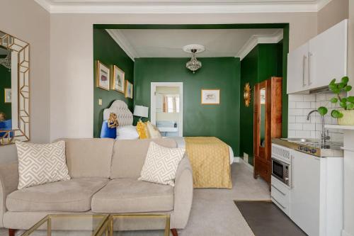 布莱顿霍夫Deco Studio: King bed, kitchenette, stylish & comfortable的带沙发和绿色墙壁的客厅