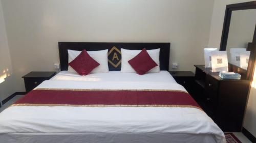 Al Nairyahالعييري للشقق المفروشة النعيريه 4的一间卧室配有红色和黑色枕头的床