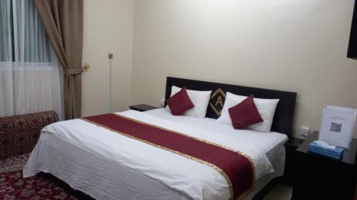 Al Nairyahالعييري للشقق المفروشة النعيريه 4的一间卧室配有一张带红色枕头的大床