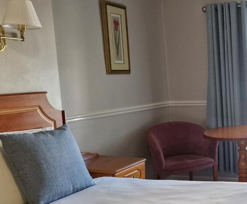 巴利海吉白沙酒店的一间卧室配有一张床、一把椅子和一张桌子