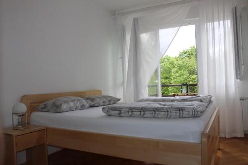 普利特维采湖Apartman Black River的一张带两个枕头的床和一个窗户