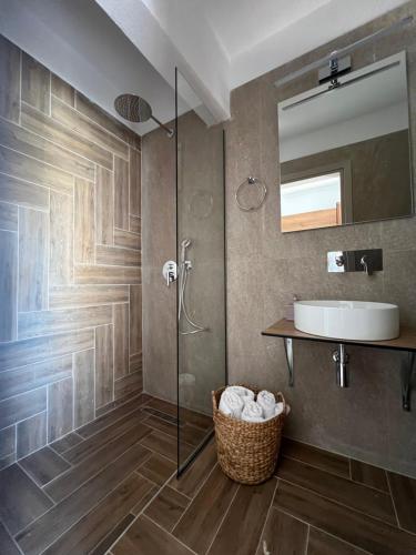 斯基亚索斯镇Pantheon的带淋浴、盥洗盆和镜子的浴室