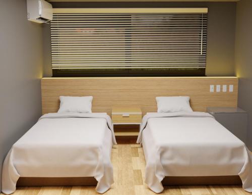 OzakiMy Home Inn Sennan, Onosato的带窗户的客房内的两张床