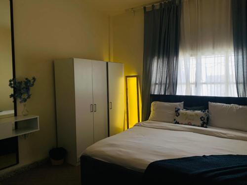马达巴Laura's Cozy HOME的一间卧室设有一张大床和一个窗户。