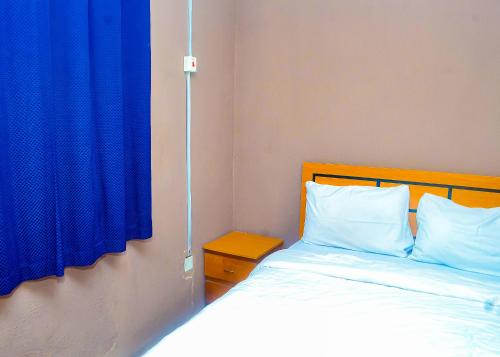 IkirunMiccom Golf Hotel and Resort的一间卧室配有一张蓝色窗帘的床