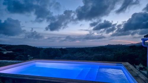 博尼法乔Ancienne bergerie de Monteleone vue mer et Citadelle的蓝色的游泳池,享有天空美景