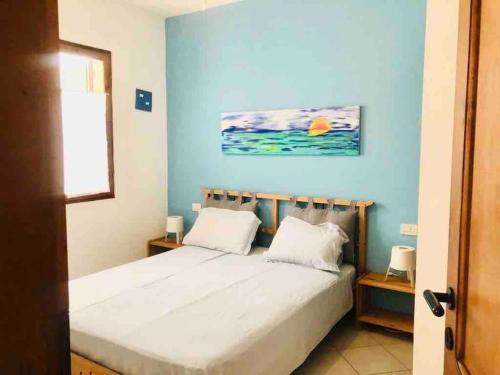 萨尔雷Ca Greta F - Sea View Apartments的一间卧室配有一张蓝色墙壁的床