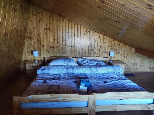 Areál Bobo的木墙客房的一张床位