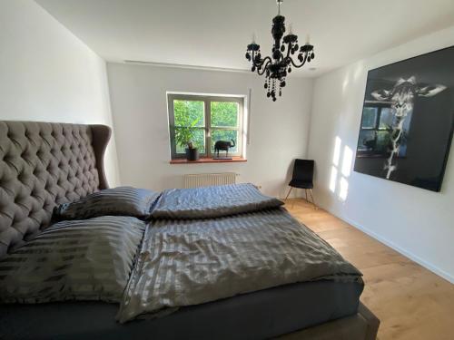维尔茨堡Wohnen in Weinbergsnähe的一间卧室配有一张大床和一个吊灯。