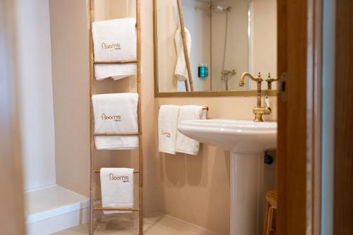 坎佩略Rooms by JovA的浴室配有盥洗盆、镜子和毛巾