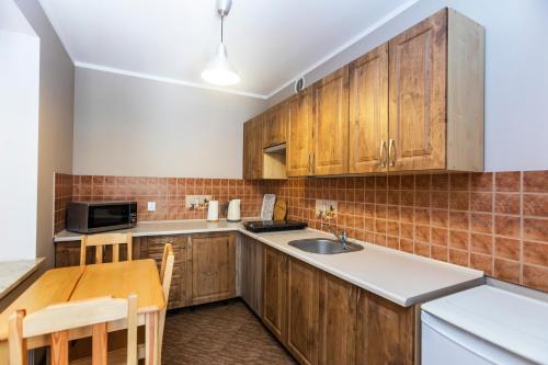 加茨比亚格拉The Village Apartment的厨房配有木制橱柜和木桌。