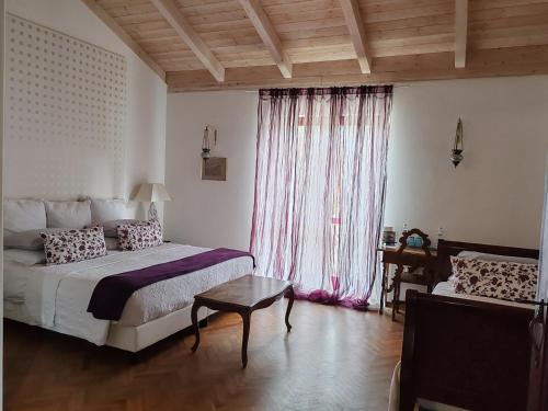 波坦察森托马尼塔维纳酒店的一间卧室配有一张床、一张桌子和一个窗户。