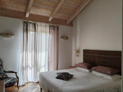波坦察森托马尼塔维纳酒店的一间卧室设有一张大床和一个窗户。