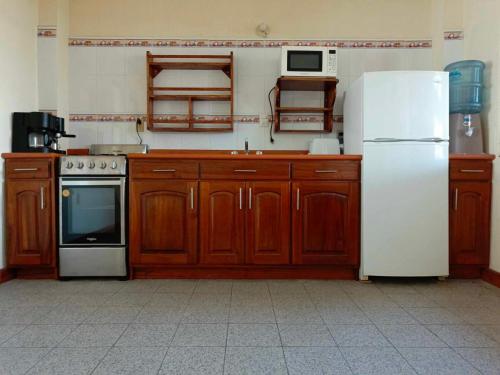 克萨尔特南戈Casa Xelaju Apartments的厨房配有木制橱柜和白色冰箱。