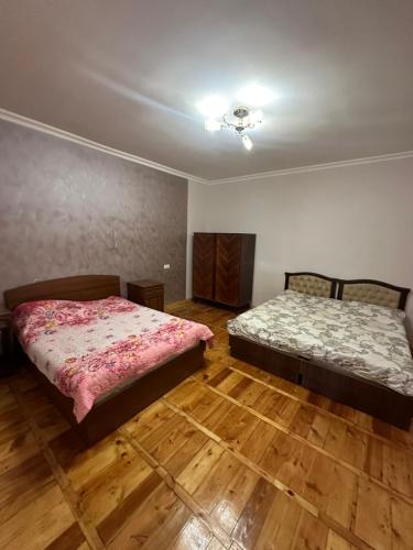 ZarritʼapʼZaritap Guest House的铺有木地板的客房内的两张床