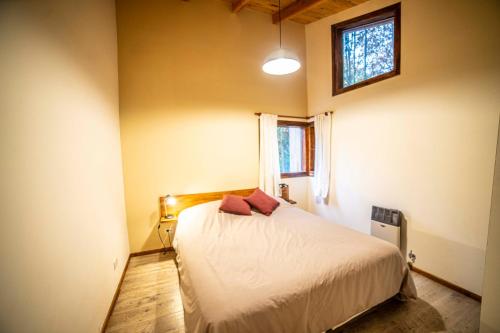 圣卡洛斯-德巴里洛切Casa en entorno de bosque, cerca de playas y cerros的一间卧室设有一张床和一个窗口