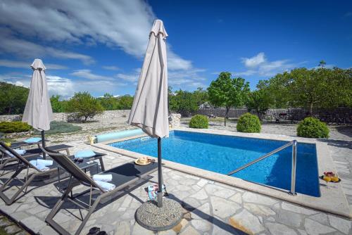Duge NjiveVilla Silentio, complete privacy near Makarska的游泳池旁的游泳池配有两把遮阳伞和两把椅子