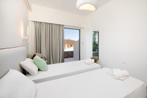 达西亚Little Corfu的白色客房 - 带2张白色床和窗户